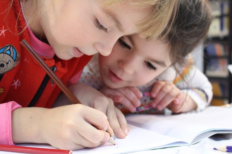 Mains dessinant dans un carnet avec des crayons de couleur
