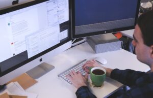Homme assis à un bureau, réfléchissant à un projet de reconversion professionnelle